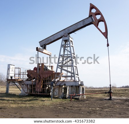 Oil pumps. Oil rocking chair. Oil industry equipment. Oil rocking chair closeup. Oil rocking chair on a background of blue sky. The pumping unit as the oil pump installed on a well.