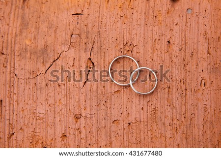 Wedding rings on red brick background