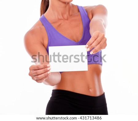 Woman holding copy space with both hands in front of her in shape body while wearing violet and black gymnastic clothing on a white background