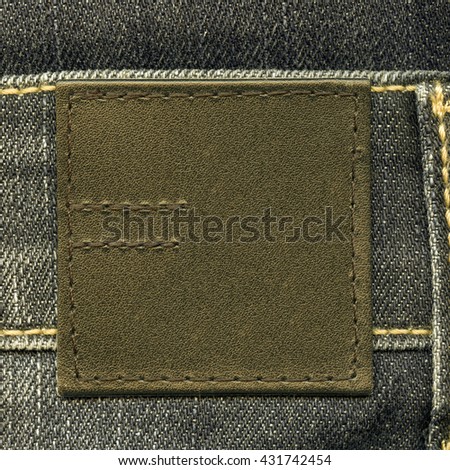 mustard-color leather label on jeans background