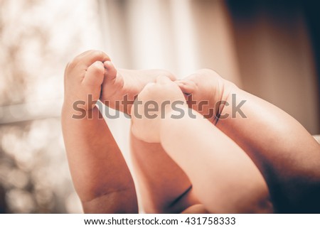 Baby holds his small hands their feet close-up