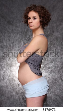Happy pregnant woman over black
