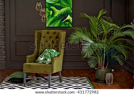 stylish interior - a green chair, flower, picture and original chandeliers