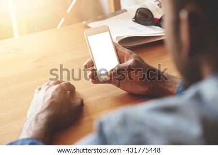 Film effect. Cropped shot of young African entrepreneur using high-speed Internet connection on cell phone with copy space screen for your advertising content before meeting with business partners