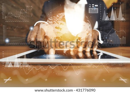 Visual effects. Worldwide connection technology interface. Young businessman sitting at the wooden table wearing formal suit, using futuristic electronic device for working at the cafe. Film effect