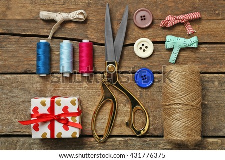 Sewing creative accessories on wooden table, top view