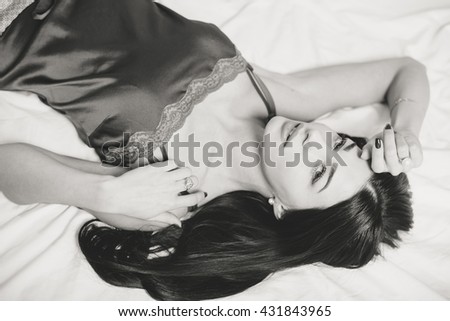 Portrait of beautiful lady relaxing in bed background, black white picture