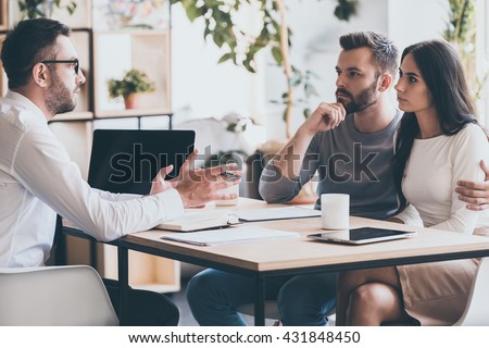 They need an expert advice. Young couple sitting together at the desk and listening to their financial advisor  Royalty-Free Stock Photo #431848450