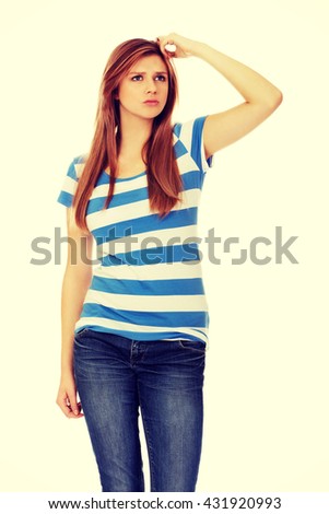 Pensive teenage woman scratching her head