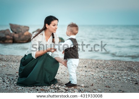mother with her baby boy on the beach at sunset