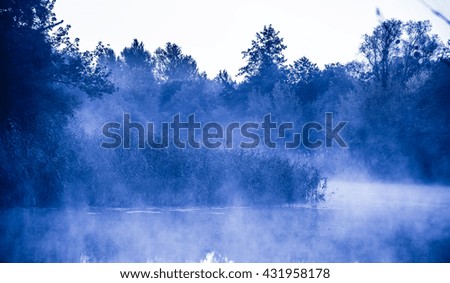 Morning fog on a calm river, tranquil scene on Severskiy Donets river, Ukraine, natural background with cold color toned image