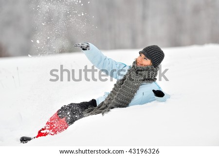 young beautiful woman playing in the snow