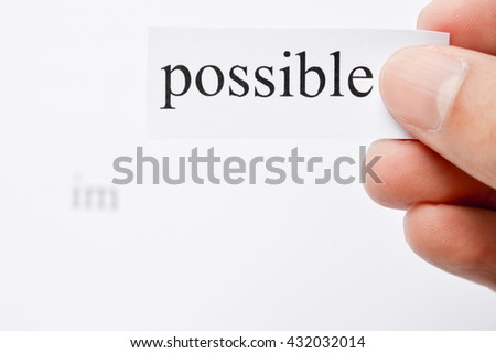 Possible Concept. Changing The Word Impossible to Possible. Seperate word im and possible.  hand holding possible words. word im on white paper. Focus at text or words.