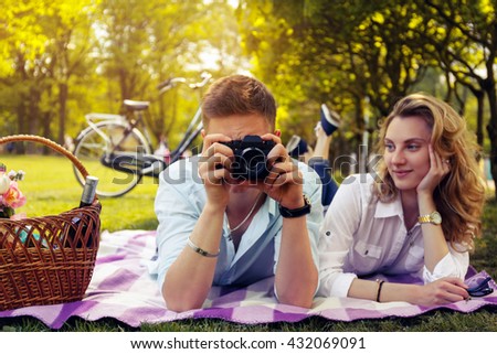 Romantic couple doing foto pictures on picnic time in a park.