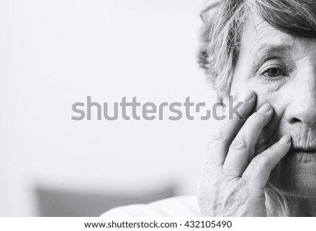 Saddened and afraid  older woman is touching face Royalty-Free Stock Photo #432105490