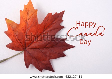 Happy Canada Day symbolic maple leaf on a white wood table with copy space and sample text. 