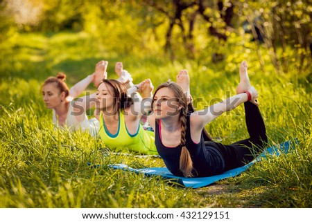 Young girls yoga in the park. Relax in nature