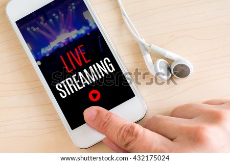 Hand touch smart phone and ear phone with Live Streaming word on wood table ,Internet marketing concept. Royalty-Free Stock Photo #432175024