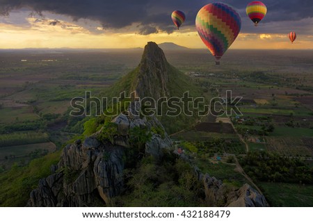 Colorful hot-air balloons flying over the mountain at Sunset