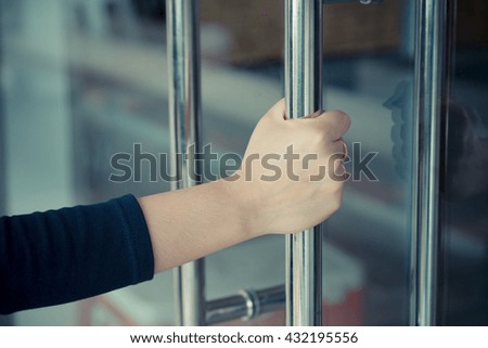 Woman's hand open the door with glass reflection background