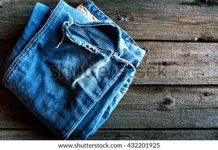 Neatly folded jeans on wooden background. Clothing, fashion, style, lifestyle