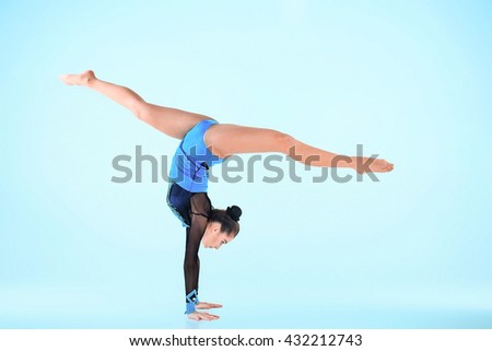 The girl doing gymnastics dance on a blue background