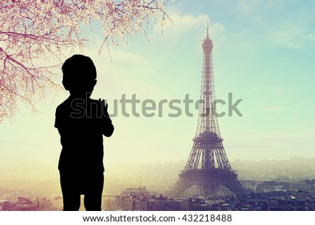 silhouette of a child at window with  Silhouette of Eiffel tower at Paris, France on a background.