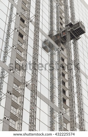 Worker rises on skyscrapers with glass facade. Modern buildings in Paris business district. Concepts of economics, financial, future, engineering.  Copy space for text. Dynamic composition