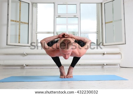 Sporty man practicing yoga. Sitting in squat, Garland pose, Malasana 