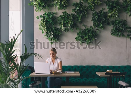 She has a busy coffee break.Woman  working on laptop in cafe bar Royalty-Free Stock Photo #432260389