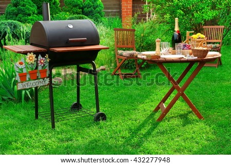 Concept For BBQ or Picnic  or Party Scene With Charcoal Grill, Served Table With Bottle Of  Champagne Wine And Welcome Sign on the Backyard Royalty-Free Stock Photo #432277948