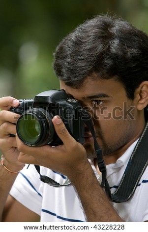 Man holding camera. Taken from side angle.