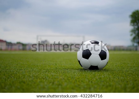 soccer ball with soccer goal on a green lawn