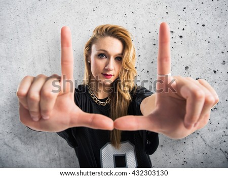 Woman focusing with his fingers over grey background