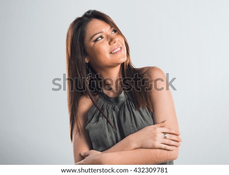 Young girl thinking over grey background