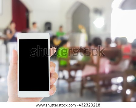 woman use mobile phone and blurred image of children worship in the church