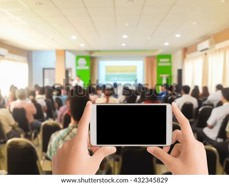 woman use mobile phone and blurred image of classroom meeting