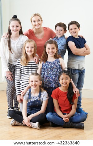 Group Of Children With Teacher Enjoying Drama Workshop Together