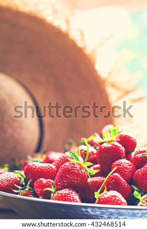 
Dish with strawberries and straw hat. 