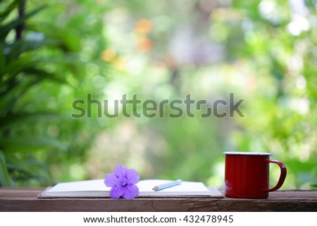 Red mug and notebooks with flower