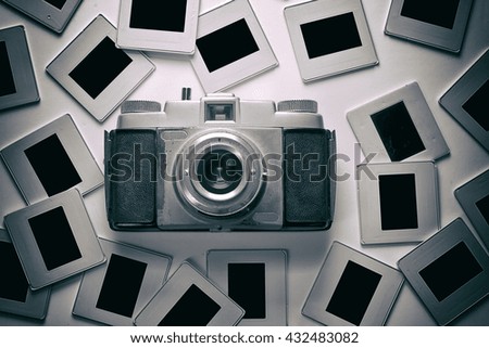 Old camera and slides on white background