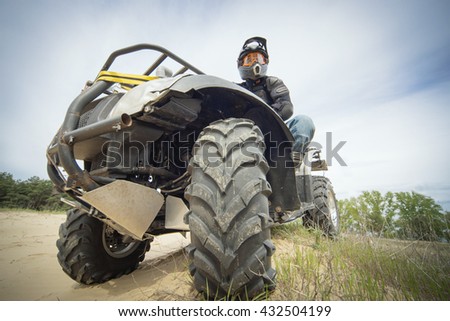 Racing ATV on the sand in summertime. Royalty-Free Stock Photo #432504199