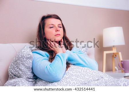 Young woman has strong sore throat Royalty-Free Stock Photo #432514441