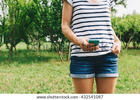 Close-up of a young woman using a smartphone in nature