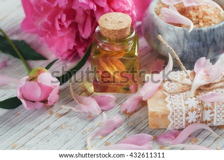 SPA concept: composition of spa treatment with natural sea salt, aromatic oil and peonies flowers on white wooden background