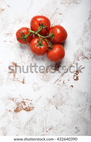 Bunch of fresh red tomatoes for use as cooking ingredients in the foreground with copy space. Top view. 
