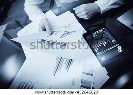 Investment manager working process.Photo trader work market report documents.Using electronic devices.Work graphic icons,stock exchanges reports screen.Business project startup.Horizontal,black white