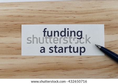 funding a startup- the concept of  entrepreneur management message on wood background with pen / pencil