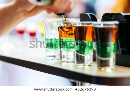 Party shots. Close up of beautiful shots coctails. Bartender pouring shots cocktails on the bar counter Royalty-Free Stock Photo #432676393