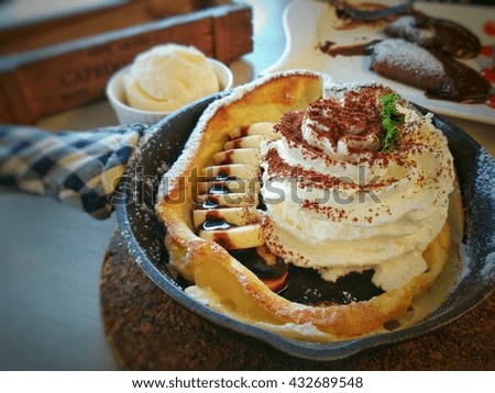 Closeup of a pancake with banana and vanilla ice cream on a hot pan,select focus.